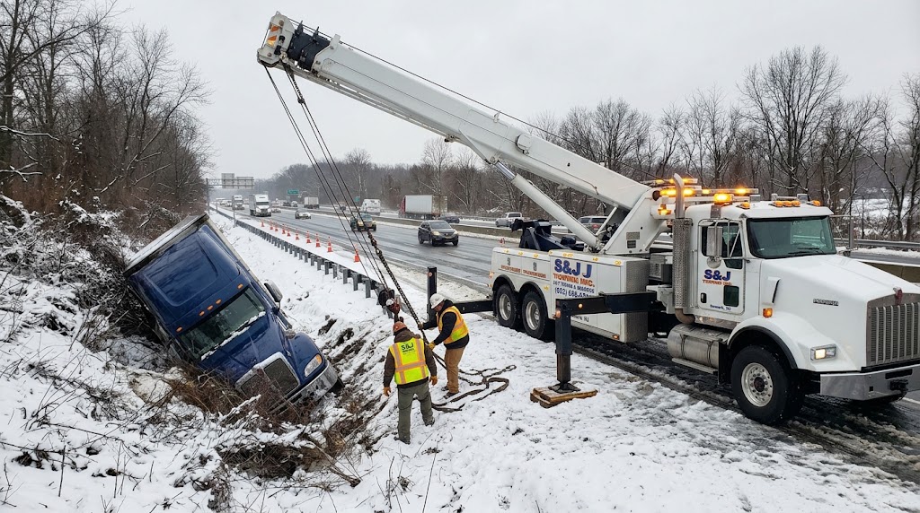Rotator crane truck clearing a jackknifed tractor-trailer